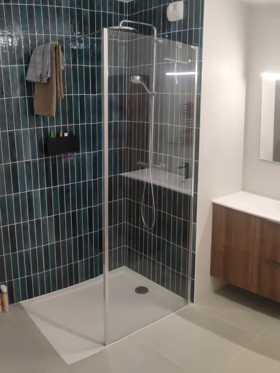 Salle de bains rénovée avec douche et meuble vasque